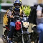 motociclista pilotando moto popular no trânsito urbano brasileiro