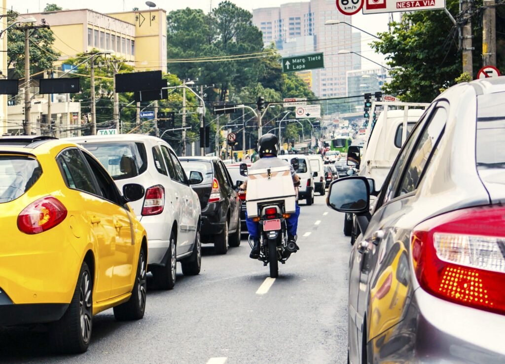 Grande quantidade de motos circulando entre carros no trânsito urbano brasileiro